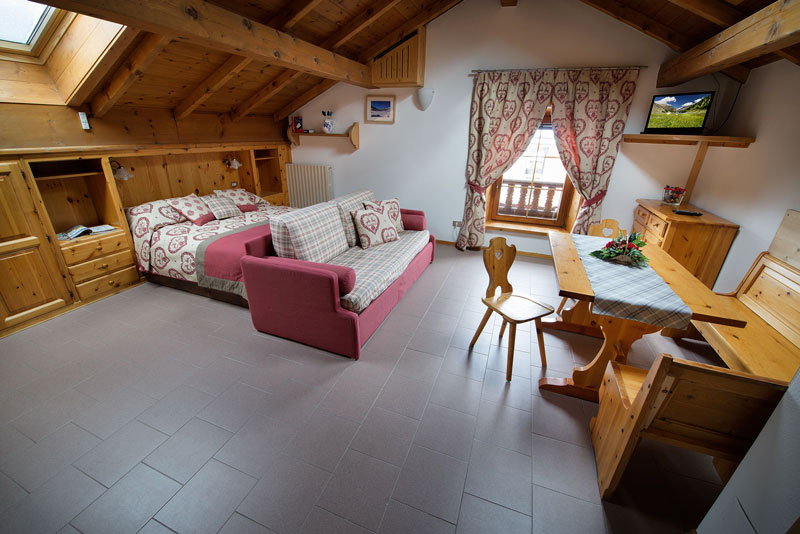 Camera accogliente in mansarda con mobili in legno e decorazioni rustiche.